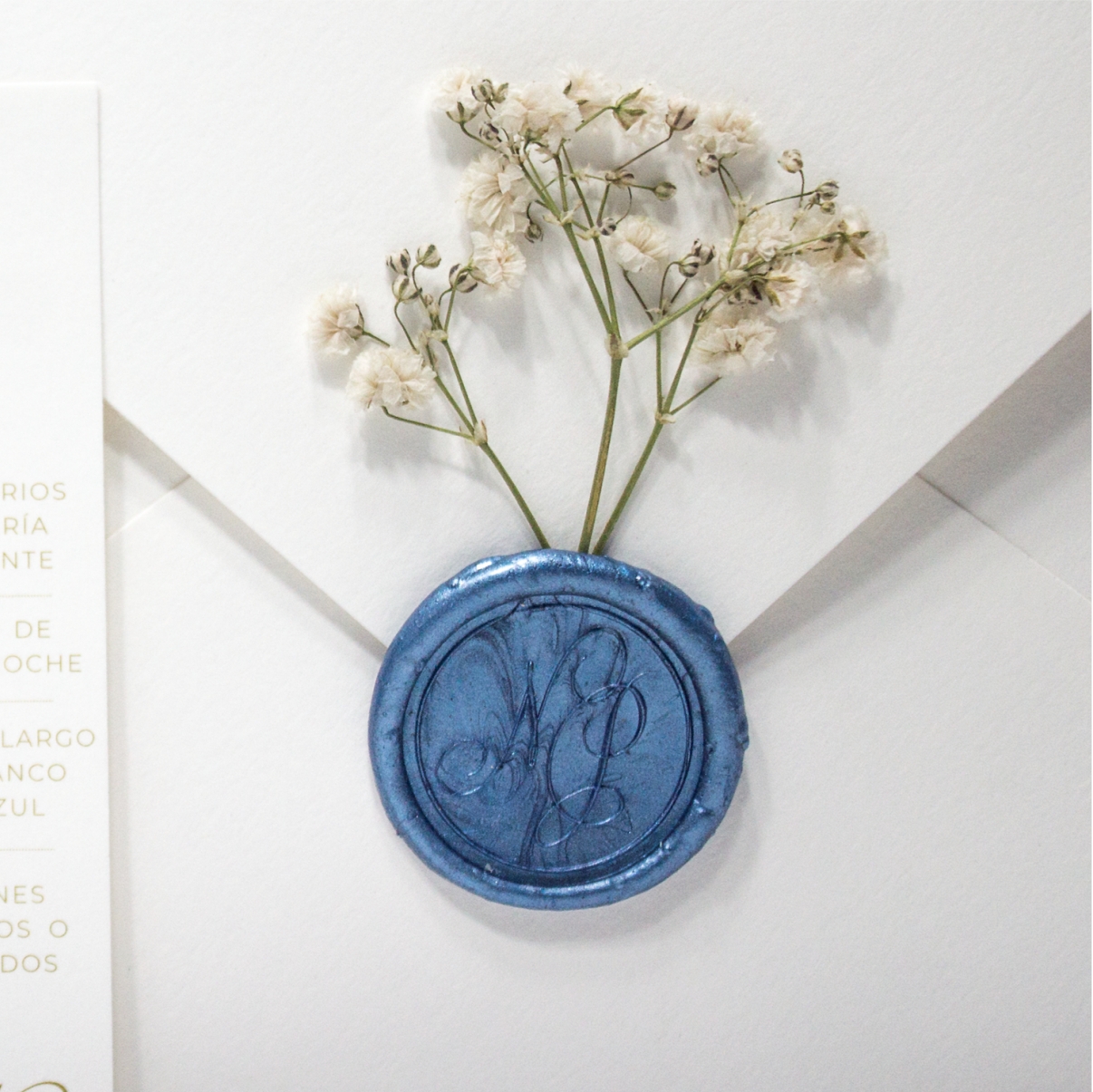 Sello de lacre personalizado azul real con iniciales grabadas, ideal para invitaciones de boda elegantes.