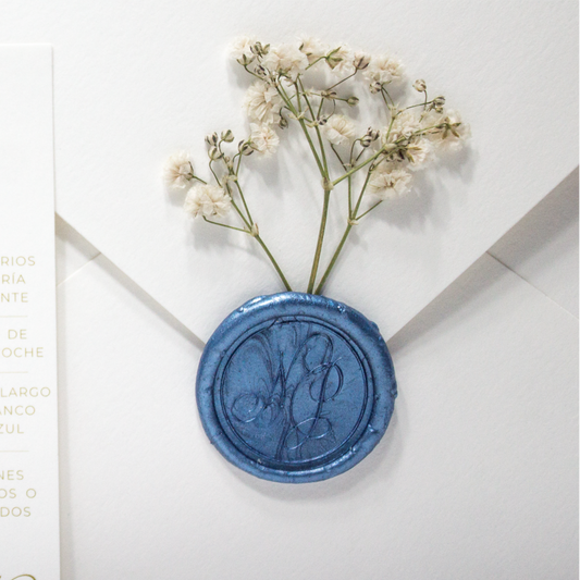 Sello de lacre personalizado azul real con iniciales grabadas, ideal para invitaciones de boda elegantes.