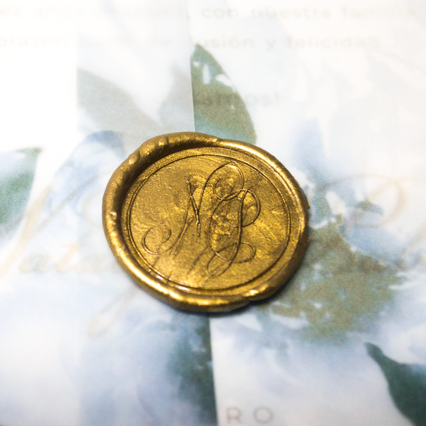 Sello de lacre personalizado azul real con iniciales grabadas, ideal para invitaciones de boda elegantes.